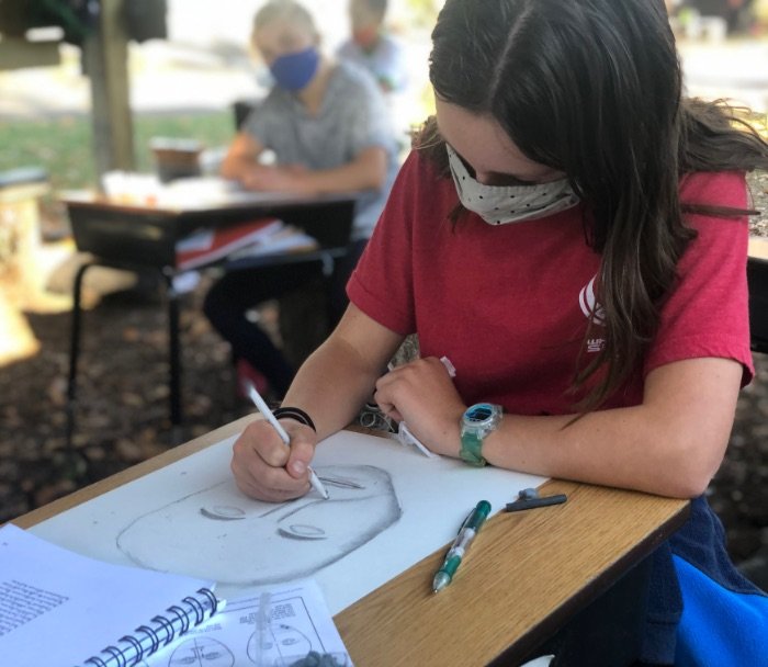 student drawing in outdoor classroom